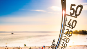 People on beach during heatwave with thermometer 
